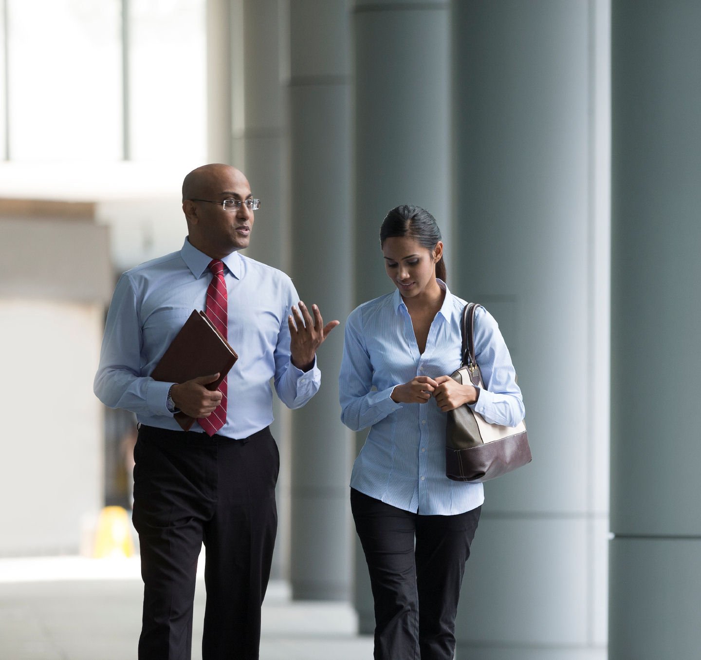 Happy Indian Business colleagues walking outside office.